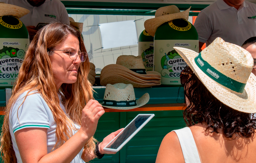 Una educadora ambiental utilizando una tablet para transmitir el mensaje de la sostenibilidad a transeuntes.